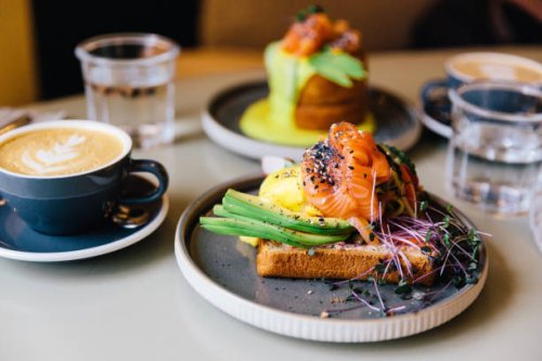 avocado toast with salmon and poached egg served for breakfast at a cafe - food stock pictures, royalty-free photos & images