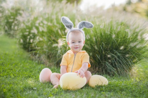 baby 10 months old with easter eggs and bunny ears. child is hunting for easter eggs in garden. - garden decoration stock pictures, royalty-free photos & images