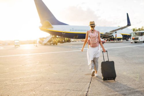 back view of a woman walking towards the plane, ready to board and begin her vacation - travel stock pictures, royalty-free photos & images