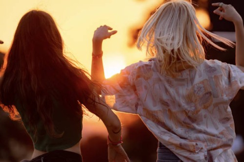 back view of carefree women dancing on music festival at sunset. - concert stock pictures, royalty-free photos & images