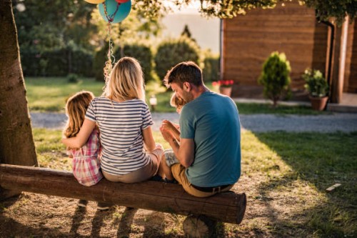 back view of relaxed family on a bench in the backyard. - garden decoration stock pictures, royalty-free photos & images