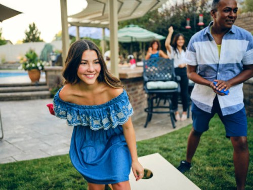 backyard party jouer au jeu de lancer de sac de haricots cornhole - garden decoration photos et images de collection