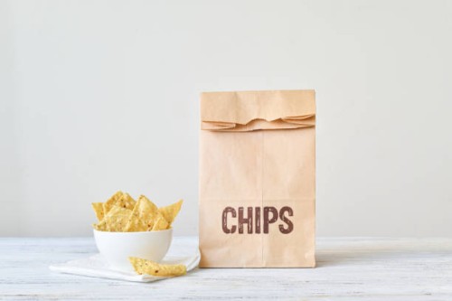 bag of tortilla nacho chips in a bowl - junk food stock pictures, royalty-free photos & images