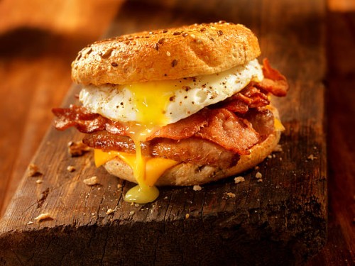 bagel, bacon, sausage and egg breakfast sandwich - junk food stock pictures, royalty-free photos & images
