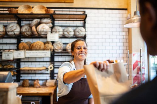 bakery owner giving food package to customer - junk food stock pictures, royalty-free photos & images