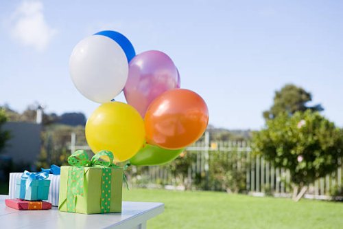 balloons and birthday presents on table in garden - garden decoration stockfoto's en -beelden
