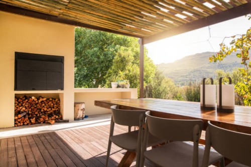 barbecue and dining table on a rustic patio on a sunny afternoon - garden decoration stock pictures, royalty-free photos & images