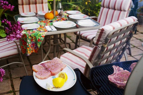 barbecue scene, outdoor table and chairs, setup for meal, barbecue grilling in foreground. - garden decoration stock pictures, royalty-free photos & images