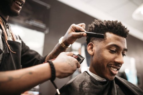 barber giving a haircut in his shop - hairstyle stock pictures, royalty-free photos & images