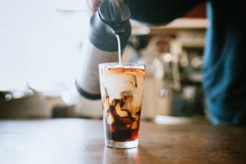 barista giet melk in koude brouwsel koffie - coffee stockfoto's en -beelden
