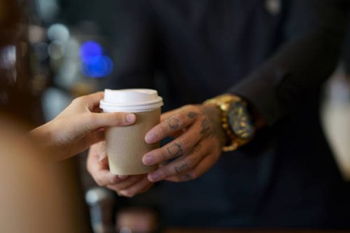 barista serving coffee in takeaway paper disposable cups to client in coffee shop - junk food stock pictures, royalty-free photos & images