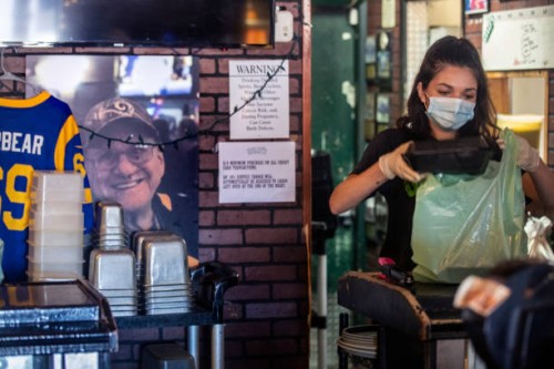 Bartender Brianna Van De Mortel packs up food to-go at Kelly's Korner on Saturday, May 16, 2020 in Placentia, CA. The sports bar is effectively...