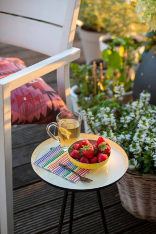 beakfast of tea and strawberries on a beautiful table in the summer sunshine garden and herbs in full bloom, flowers - garden decoration photos et images de collection