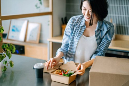 beautiful and joyful young asian woman opening the takeaway lunch box of fresh healthy salad, eating at home with food delivery services. eating at home concept - junk food stock pictures, royalty-free photos & images