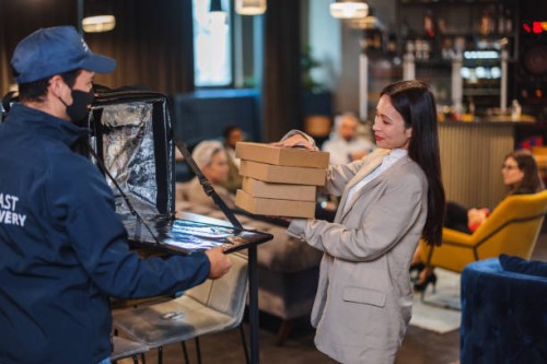 beautiful asian female personal assistant picking up a food delivery order - junk food stock pictures, royalty-free photos & images