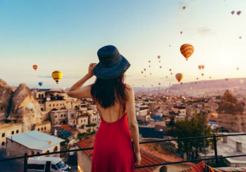 beautiful asian woman watching colorful hot air balloons flying over the valley at cappadocia, turkey. turkey cappadocia fairytale scenery of mountains. - travel stock pictures, royalty-free photos & images