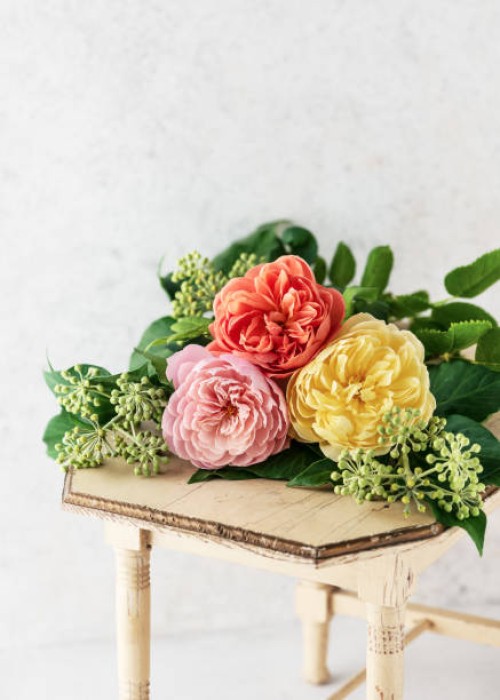 beautiful bouquet of colorful english roses with ivy blossom on a wooden vintage stool. - garden decoration stock pictures, royalty-free photos & images