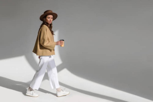 beautiful fashionable woman posing in studio on white background in studio. fashionable female walking with coffee to go. fashion concept - fashion stock pictures, royalty-free photos & images