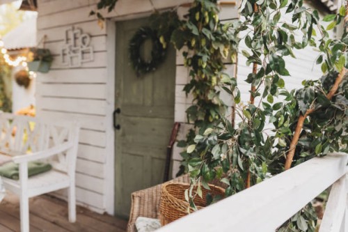 beautiful porch home with autumn decorations on thanksgiving. garden table and chairs with apples and pumpkins on autumn yard. terrace with retro light bulbs garlands. halloween. interior cozy patio - garden decoration stock 
