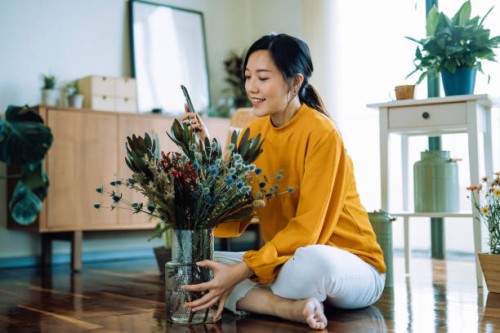 beautiful smiling young asian woman receiving bouquet of flower delivery from boyfriend, chatting on video call with smartphone. love and relationship concept. occasions for valentine's day. birthday. dating anniversary - hom