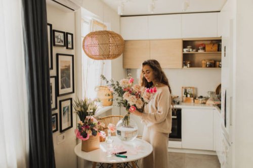 beautiful woman decorating house with flowers. - home decoration stock pictures, royalty-free photos & images