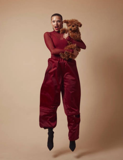 beautiful woman jumping with cute dog in her arms. - fashion stock pictures, royalty-free photos & images
