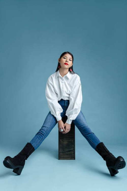 beautiful woman sitting in front of plain background - fashion stock pictures, royalty-free photos & images