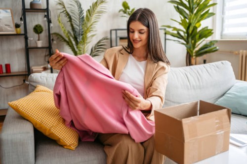 beautiful woman unpacking parcel ordered online at home - fashion stock pictures, royalty-free photos & images