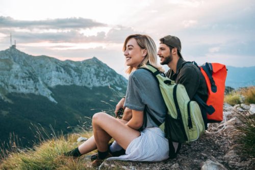 beautiful young couple relaxing after hiking and taking a break - travel stock pictures, royalty-free photos & images