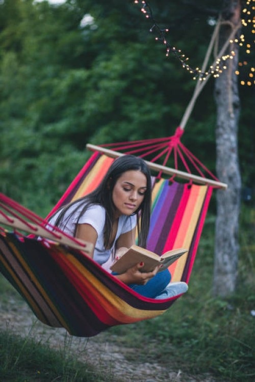 beautiful young girl lying and reading a book - garden decoration stock pictures, royalty-free photos & images