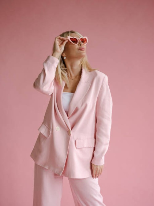 beauty shot of beautiful woman in monochromatic pink wearing heart-shaped glasses - fashion stock pictures, royalty-free photos & images