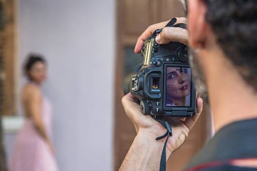 behind the scenes of an urban fashion shoot with female model and male photographer - fashion photos et images de collection
