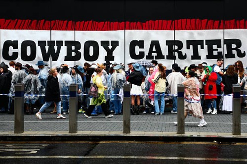Beyonce fans, also known as the "BeyHive", queue in the rain for entry at Tottenham Hotspur Stadium ahead of her second performance on June 7, 2025...