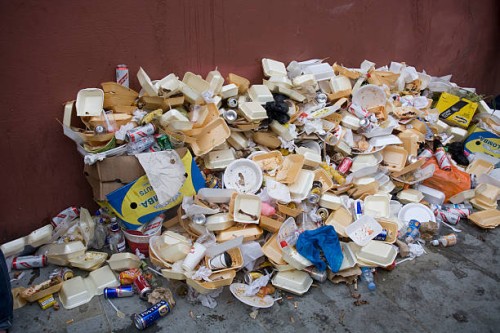 Big pile of garbage, mostly from fast-food packaging, lies on a street during the annual Notting Hill Carnival.