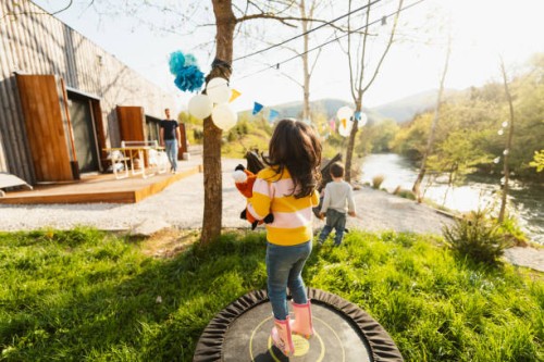 birthday girl jumping on a trampoline - garden decoration stockfoto's en -beelden