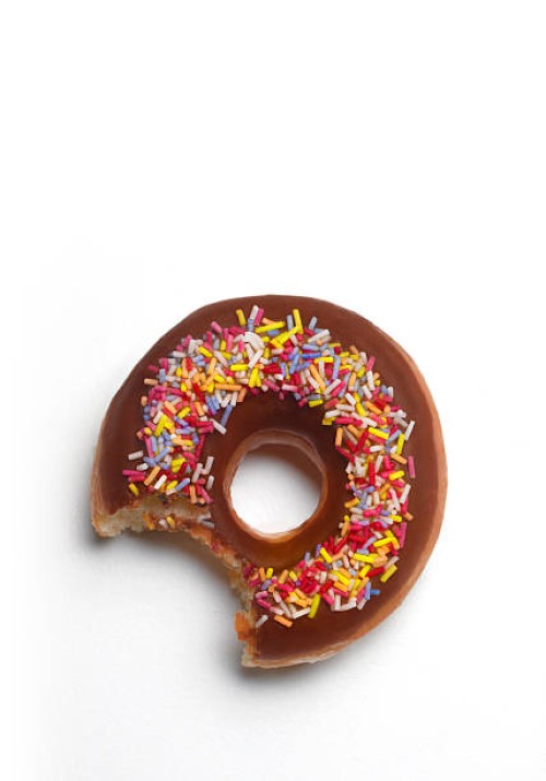 bite out of donut with copy space - junk food stock pictures, royalty-free photos & images