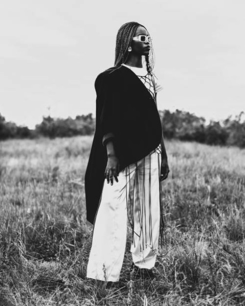 black and white photography. beautiful woman in suit and jacket outdoors. authentic style. summer fashion. model with afro hairstyle. stylish accessories. earrings. - fashion stock pictures, royalty-free photos & images