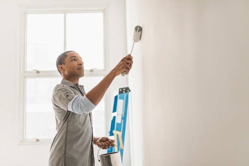 black man painting wall of home - home decoration stock pictures, royalty-free photos & images