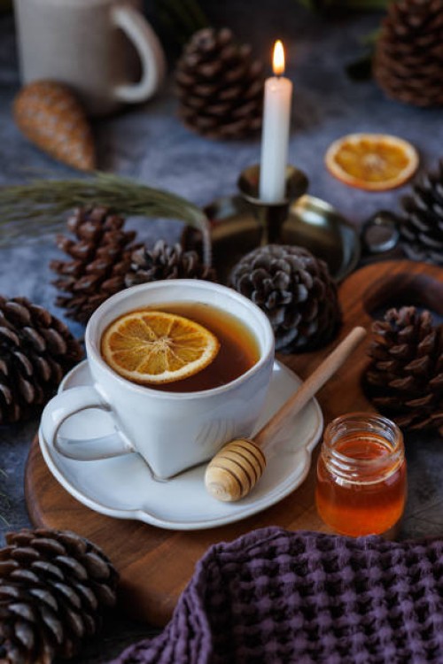 black tea with dried orange slices in a white ceramic cup on wooden presentation board - home decoration stockfoto's en -beelden