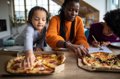black woman and her family having pizza for lunch at home - junk food stock pictures, royalty-free photos & images