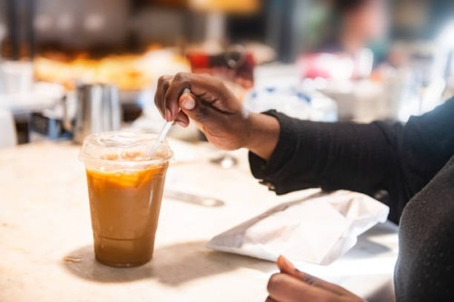 black woman's hands putting straw in iced coffee - junk food stock pictures, royalty-free photos & images