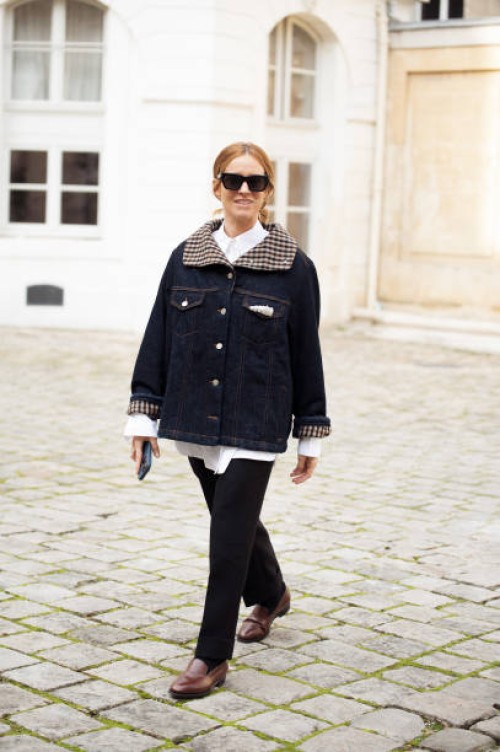Blanca Miro wears navy blue denim jacket, white top, navy blue jeans and sunglasses outside the Ganni fashion show during the Womenswear Fall/Winter...