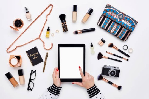 blogger utilisant une tablette numérique entourée de produits de beauté - fashion photos et images de collection