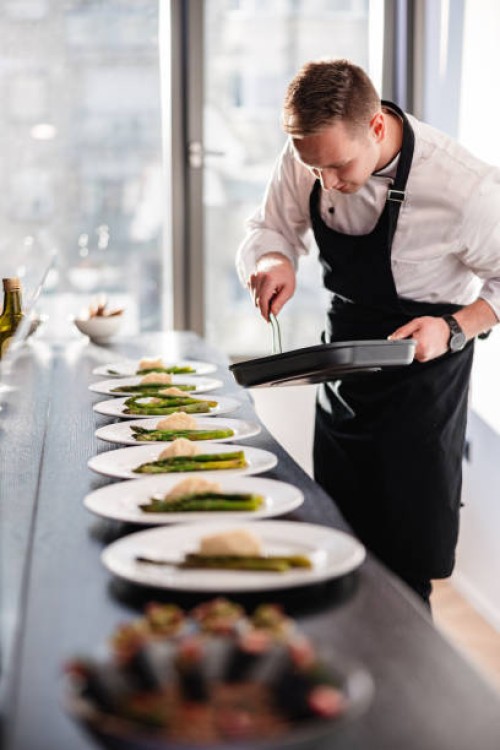 blonde caucasian male private chef plating dishes for a dinner party at a fancy apartment - food stock pictures, royalty-free photos & images