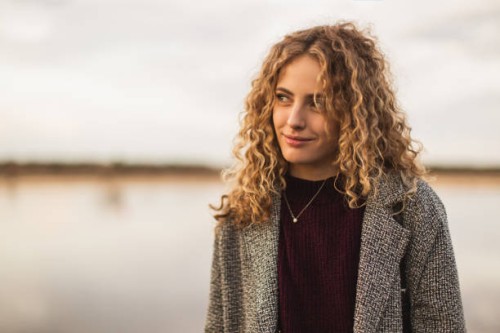 blonde curly girl in coat outdoors - fashion stock pictures, royalty-free photos & images