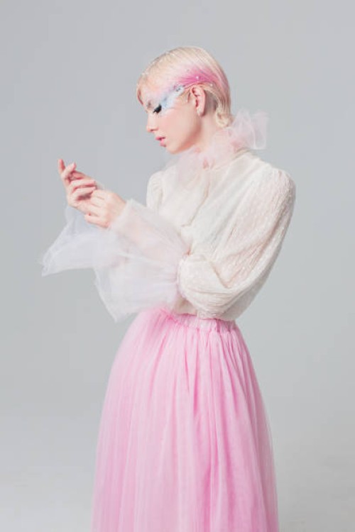 blonde girl in white blouse in studio on white background. short pink hair. model in skirt. beauty makeup with feather. style and fashion. haute couture - fashion stock pictures, royalty-free photos & images