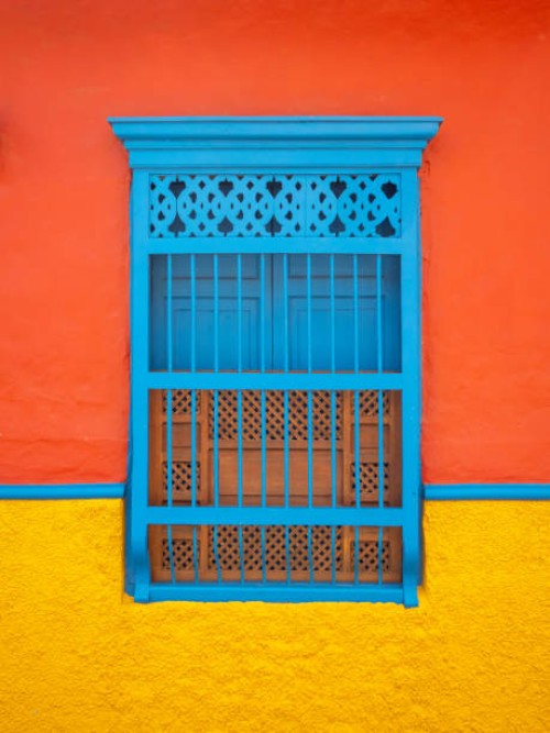 blue window in a orange and yellow background, characteristic of the town of jerico, antioquia, colombia - garden decoration stock pictures, royalty-free photos & images