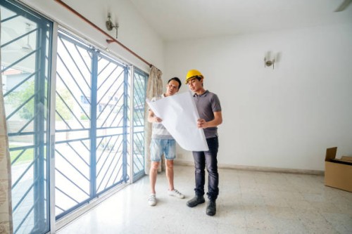 bouwvakkers die blauwdrukken in het huis met cliënten analyseren - home decoration stockfoto's en -beelden