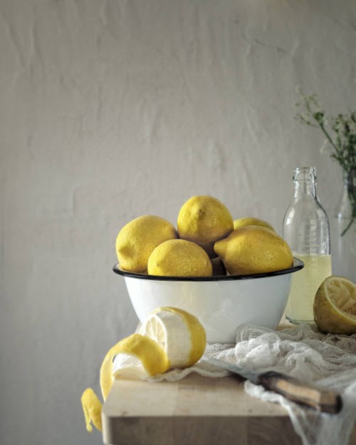 bowl with fresh lemons for making lemonade on a wooden table on a background of light textured concrete wall - home decoration stock pictures, royalty-free photos & images