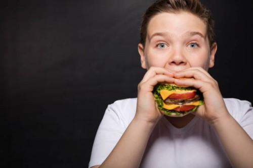 boy and hamburger - junk food stock pictures, royalty-free photos & images
